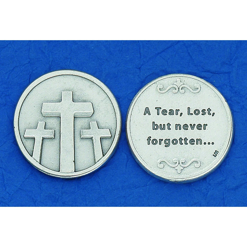 Two round silver-toned medallion coins displayed side by side on a textured blue background. The left coin features three Christian crosses, and the right coin is inscribed with the words 'A Tear, Lost, but never forgotten.